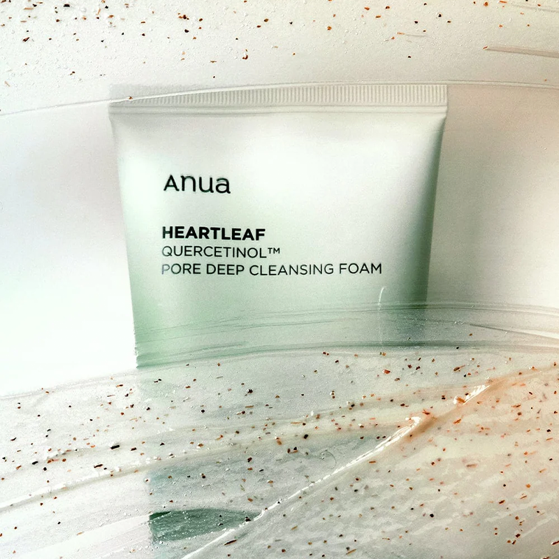 Tube, die mit einem durchsichtigen Gel und kleinen Peeling-Partikeln bedeckt ist. Die Szene wirkt frisch und reinigend.