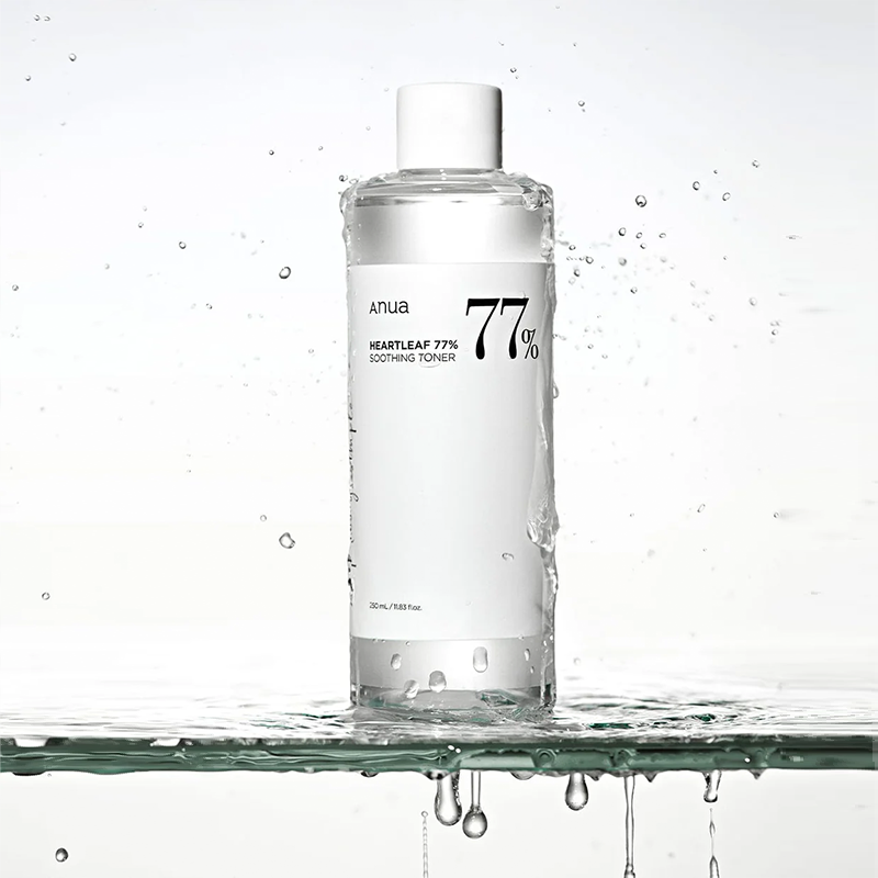 Eine transparente Flasche, bedeckt mit Wassertropfen, steht auf einer Glasplatte, von der Wasser tropft. Die Szene wirkt frisch und kühl.