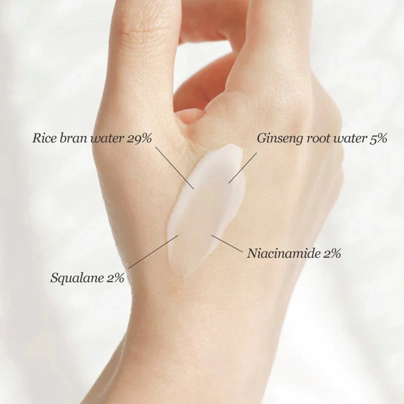 Hand mit einer Schicht Creme auf dem Handrücken, beschriftet mit den Inhaltsstoffen.