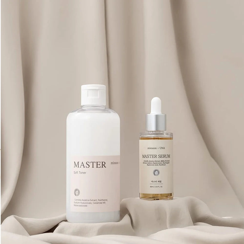Master Soft Toner und Master Serum nebeneinander auf beigem Stoff drapiert.