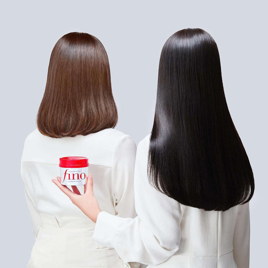 Zwei Frauen mit glänzendem, glattem Haar. Eine hält die Fino Hair Mask, die für geschmeidiges Haar präsentiert wird.
