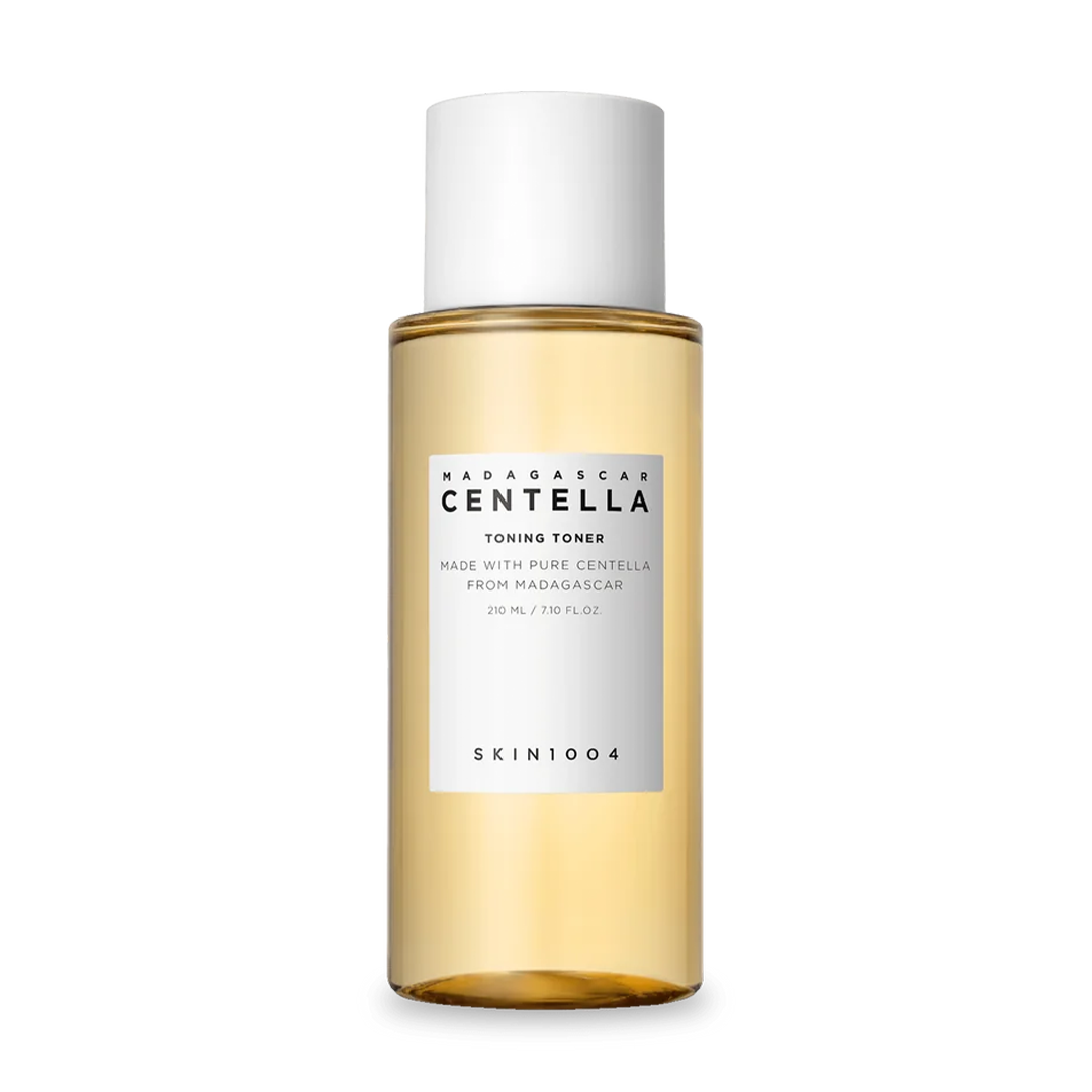 Transparente Flasche mit goldenem Toner und weißem Deckel.