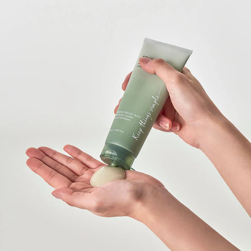Eine Hand trägt das Gel aus der Tube auf die andere Handfläche auf.