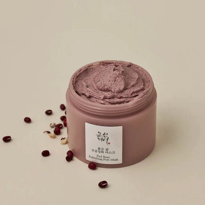 geöffneten Behälter mit einer braunen cremigen Maske und rundherum liegen kleine rote Bohnen.