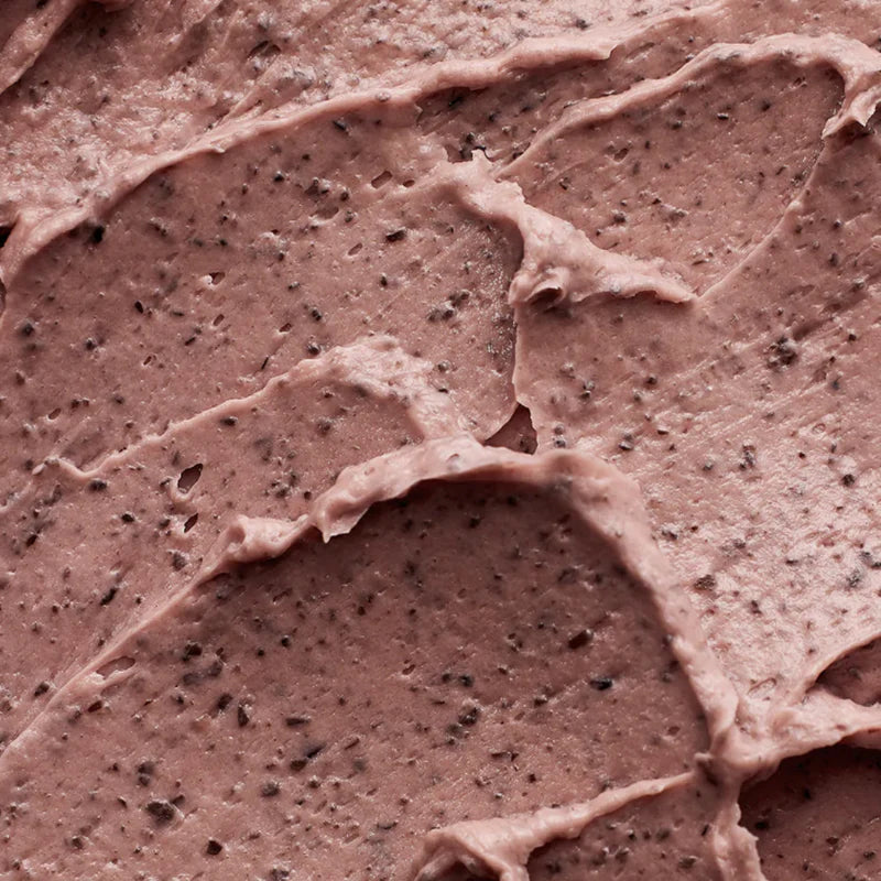 Nahaufnahme einer cremigen, braunen Textur mit feinen schwarzen Körnchen. 