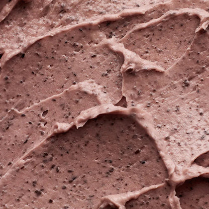 Nahaufnahme einer cremigen, braunen Textur mit feinen schwarzen Körnchen. 