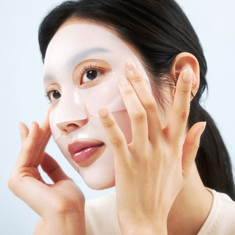 Frau legt eine transparente Gesichtsmaske auf ihr Gesicht,die Ränder passt sie mit den Fingern an.
