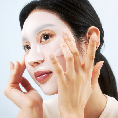 Frau legt eine transparente Gesichtsmaske auf ihr Gesicht,die Ränder passt sie mit den Fingern an.