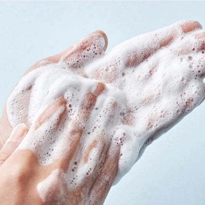 Nahaufnahme von aufgeschäumtem Cleanser in den Händen, zeigt die reinigende Textur.