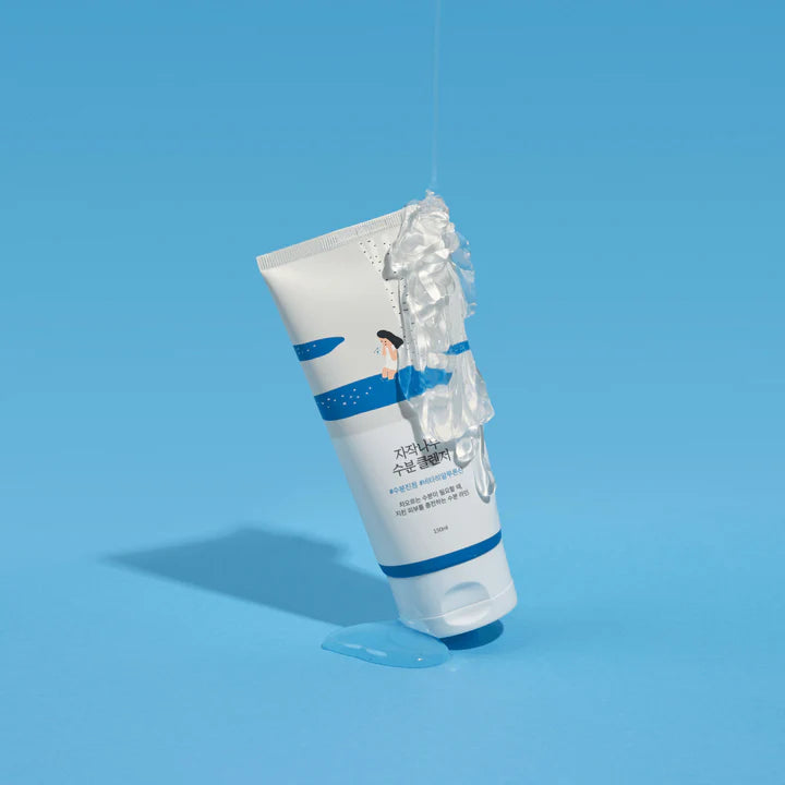 Tube in Bewegung, Wasser läuft darüber, betont Frische und Feuchtigkeit vor blauem Hintergrund.