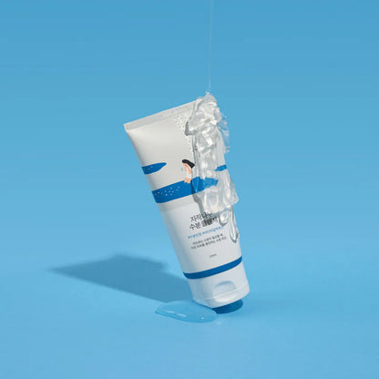 Tube in Bewegung, Wasser läuft darüber, betont Frische und Feuchtigkeit vor blauem Hintergrund.