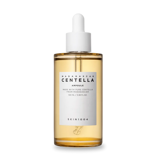 Eine Glasflasche mit einer Pipette, gefüllt mit goldener Centella-Ampoule.
