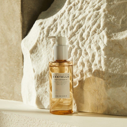 Eine Flasche Cleansing Oil, angestrahlt auf weißem Stein mit natürlicher Textur.