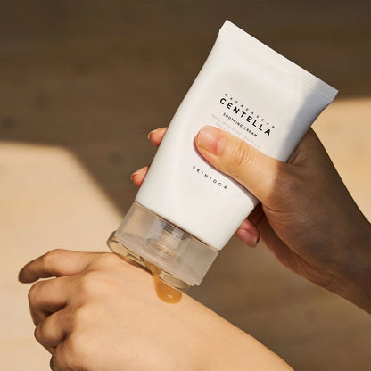 Eine Hand drückt eine goldene, durchsichtige Creme aus der weißen Tube auf den Handrücken.