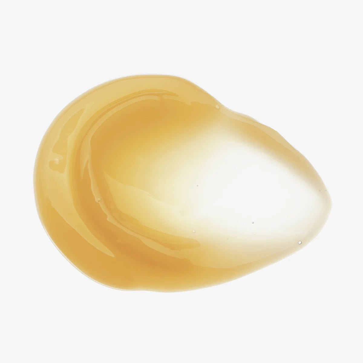 Nahaufnahme einer goldgelben, durchsichtigen Creme auf weißem Hintergrund.
